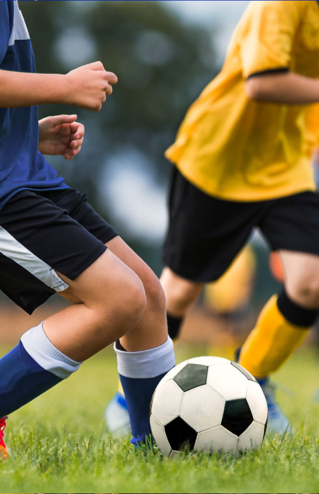 Kids playing a competitive soccer match on the field at Wvec West Valley Events Complex in Phoenix, Arizona.